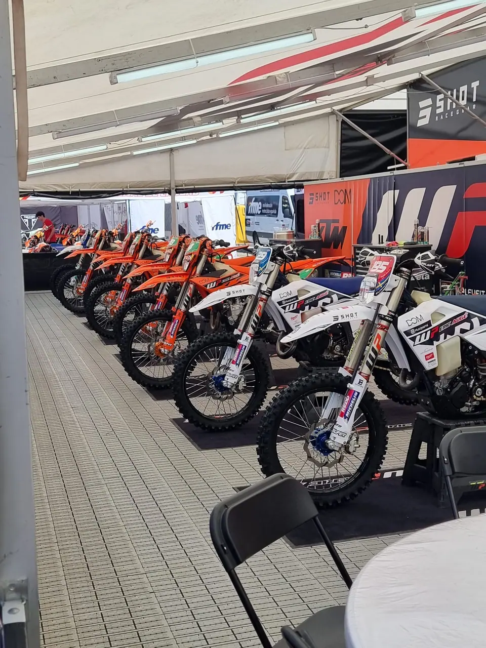 Motas alinhadas na tenda da equipa, no paddock