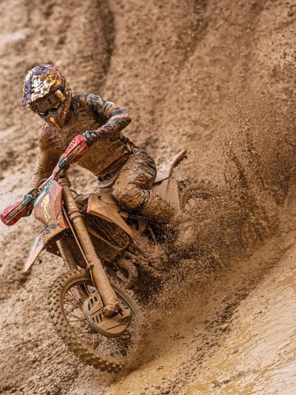 Piloto de motocross a atravessar areia funda